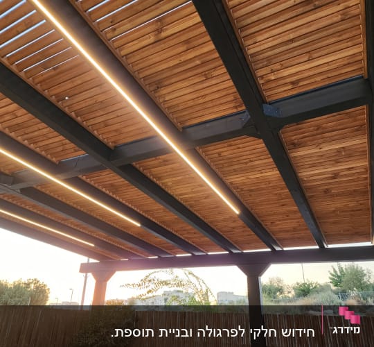 פרגולה מעץ עם תאורה מובנית בגינה